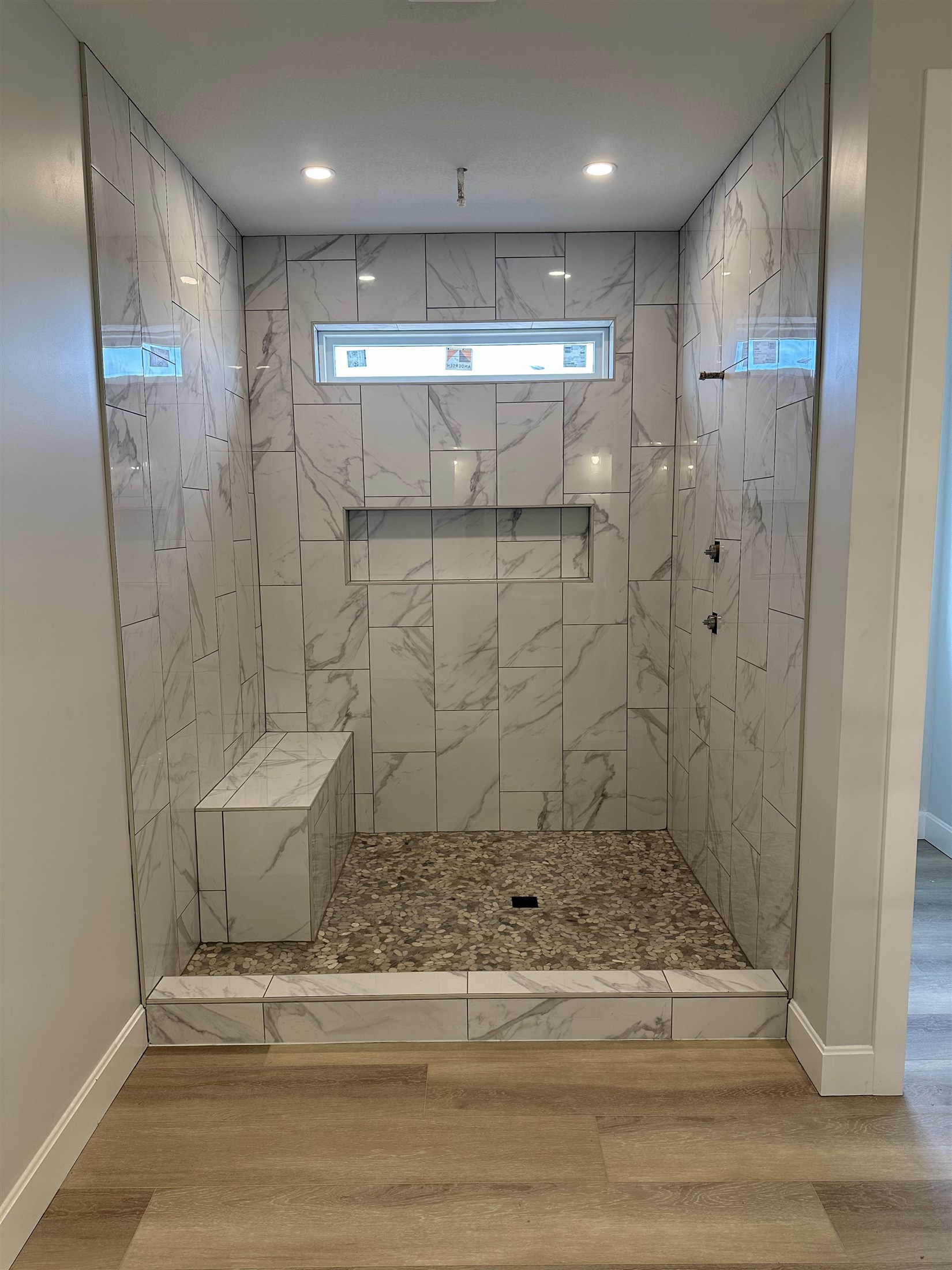 Completed Heartland Tile shower with niches and a bench