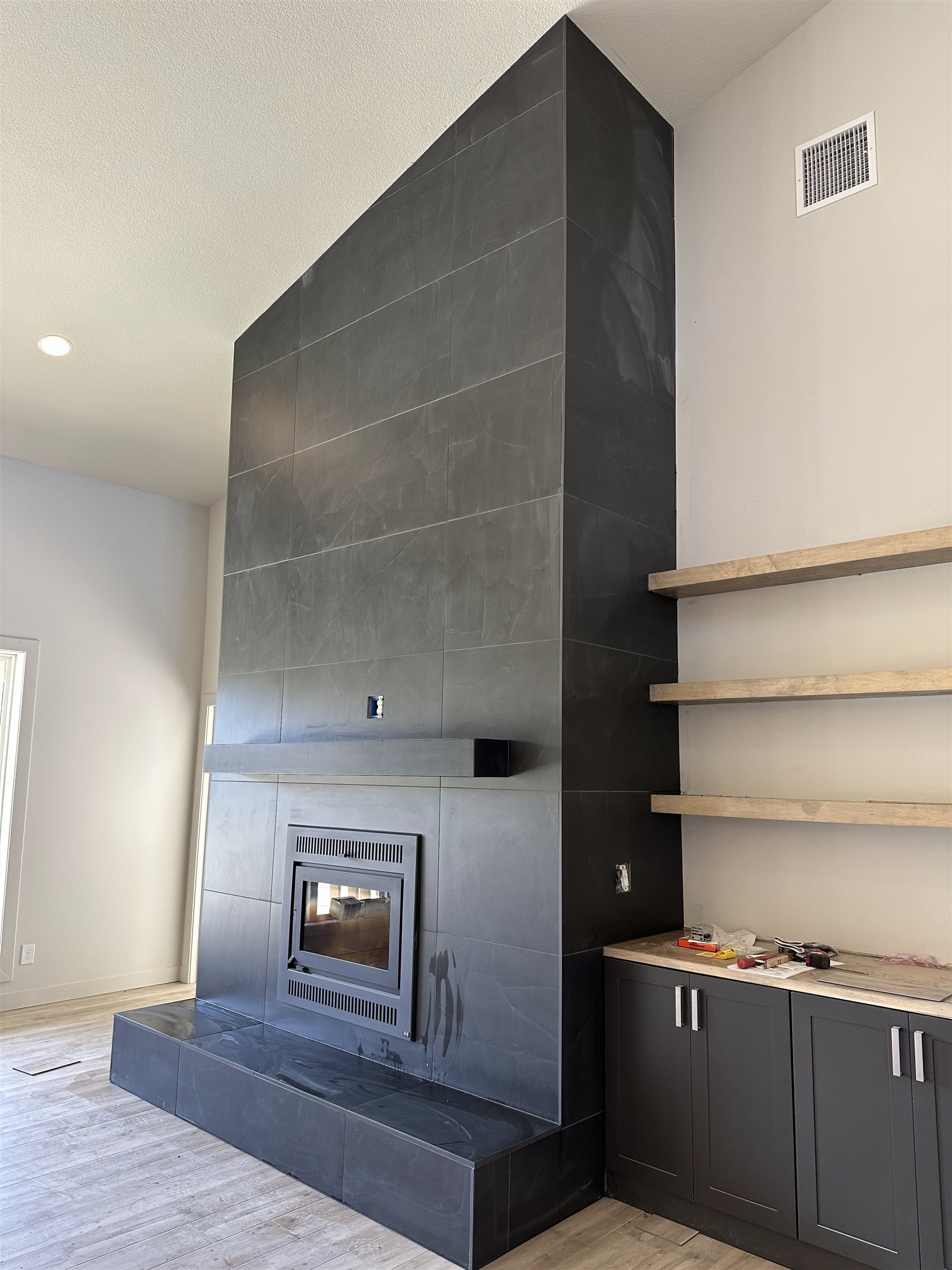 Fireplace tile & built-in shelving installed by Heartland Tile